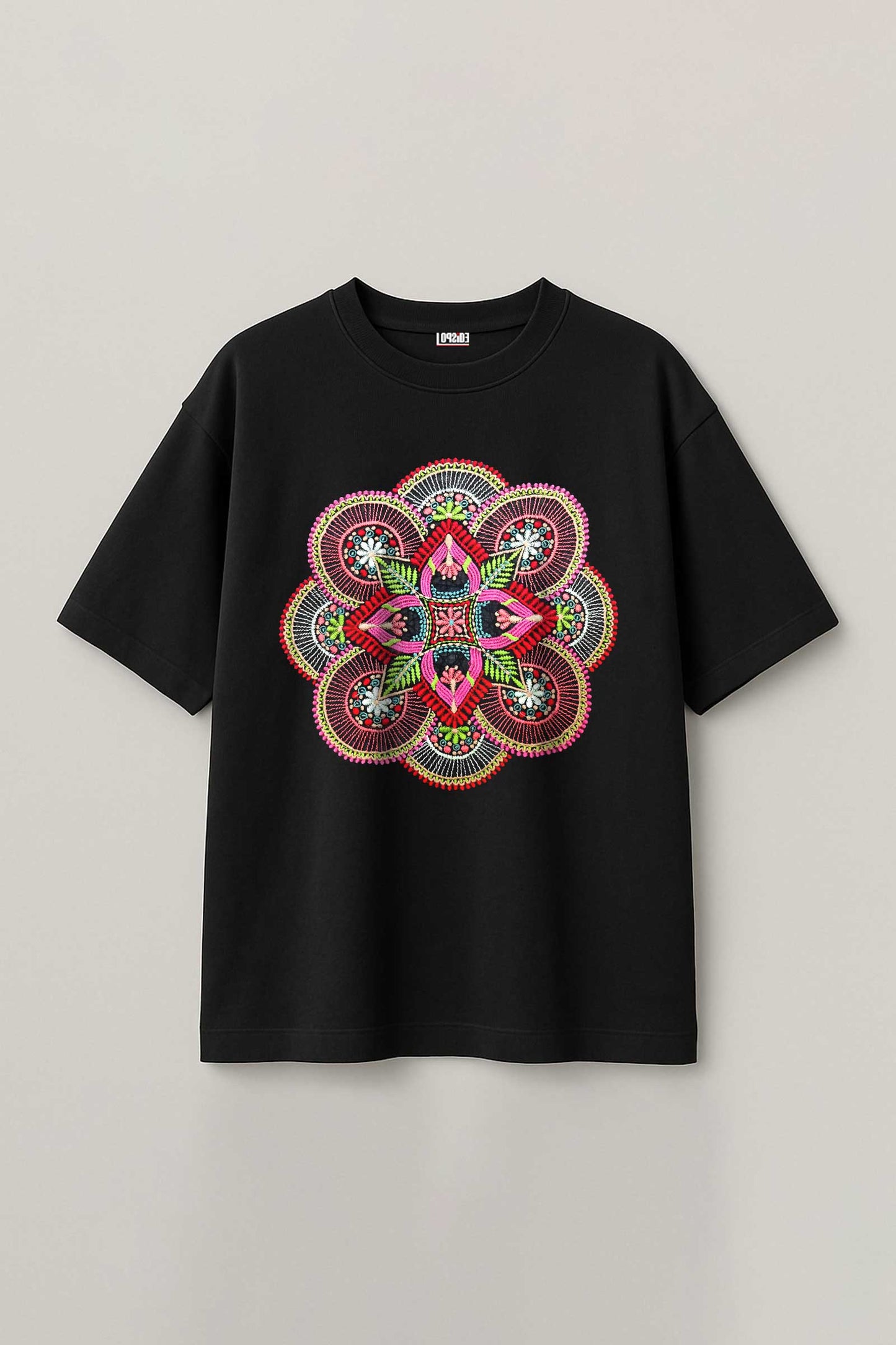 Black t-shirt with a colorful mandala design on a light gray background