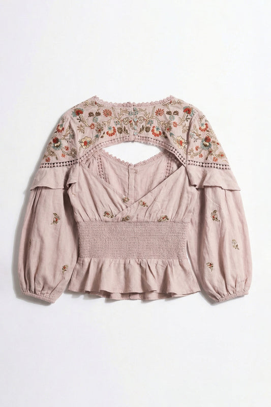 Pink blouse with floral embroidery on a white background