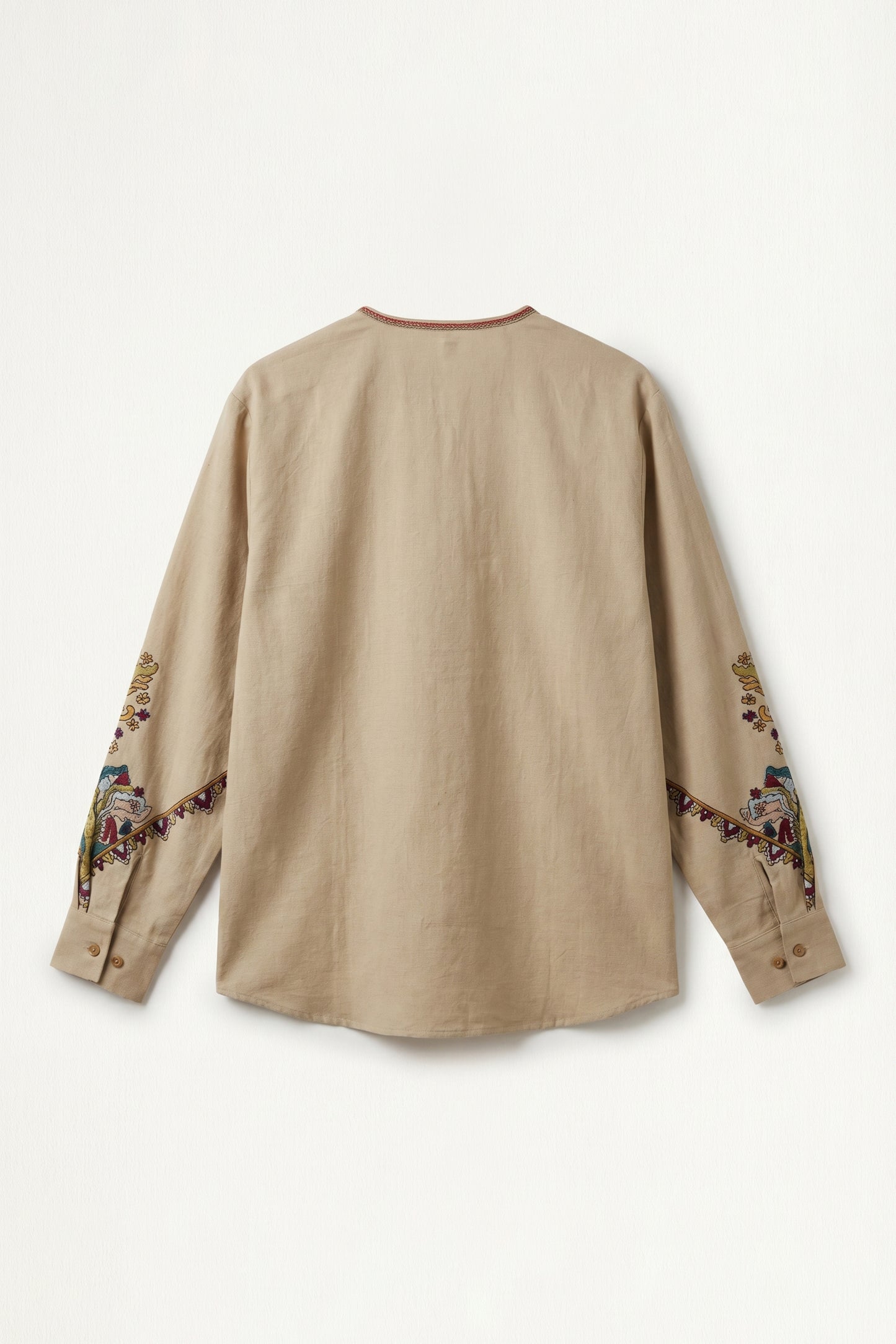 Beige long-sleeve shirt with embroidery on sleeves against a white background