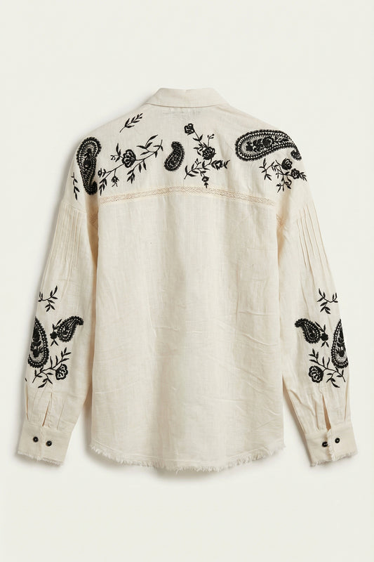 White shirt with black floral and paisley embroidery on a white background