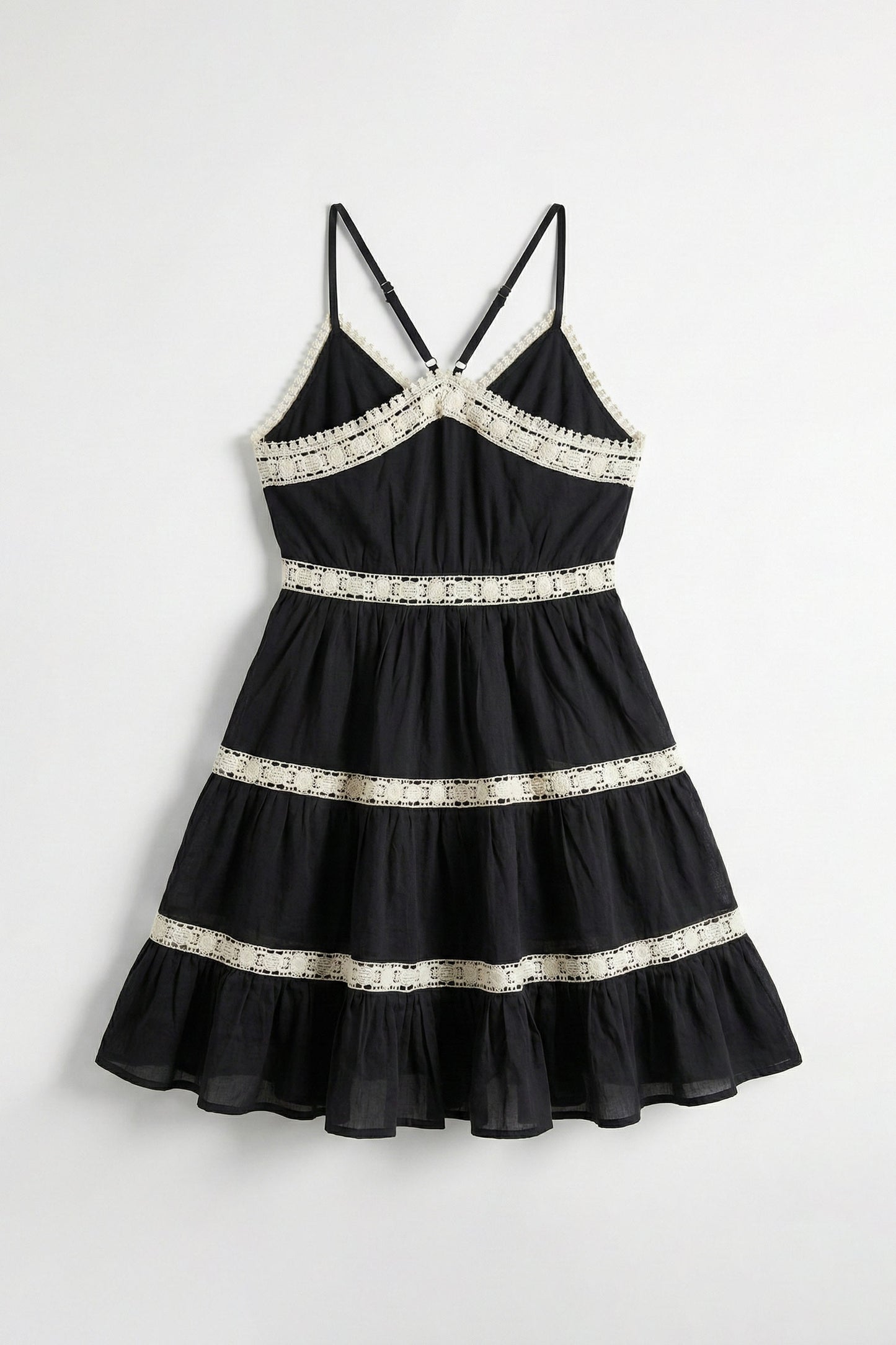 Black dress with white lace details on a white background