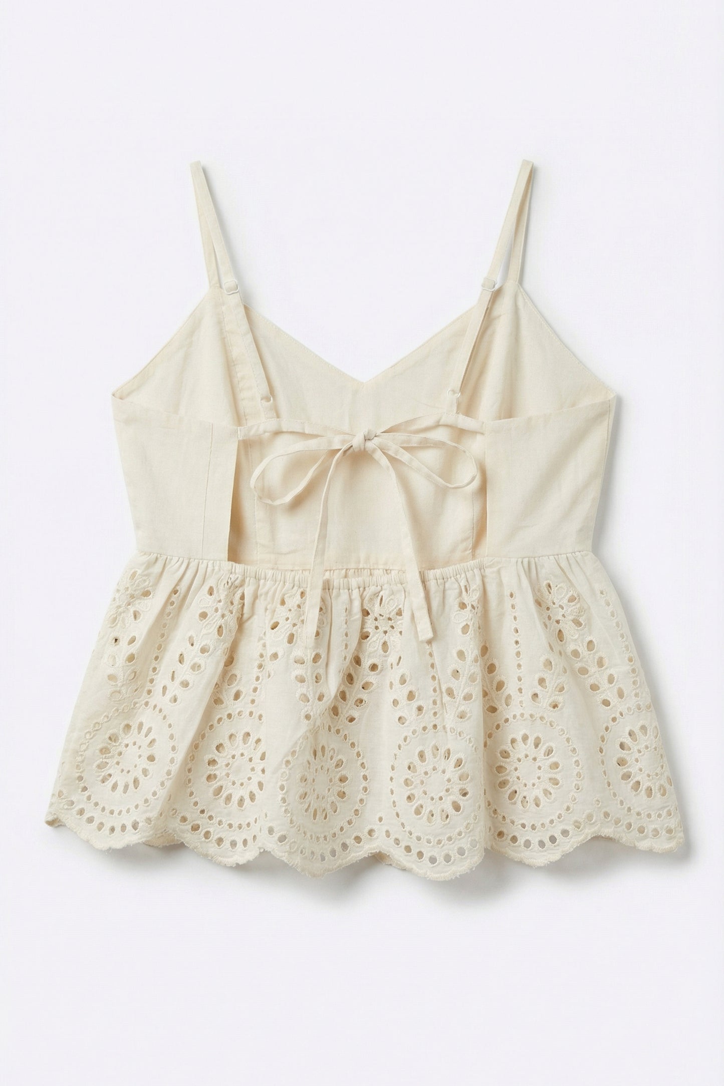 Beige lace top with thin straps on a light gray background