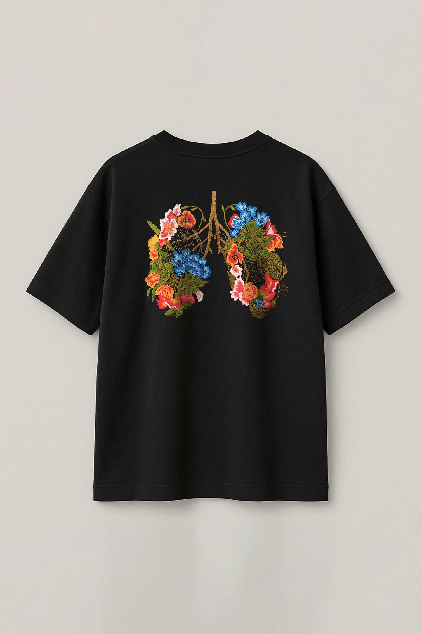 Black t-shirt with floral lung design on a light gray background