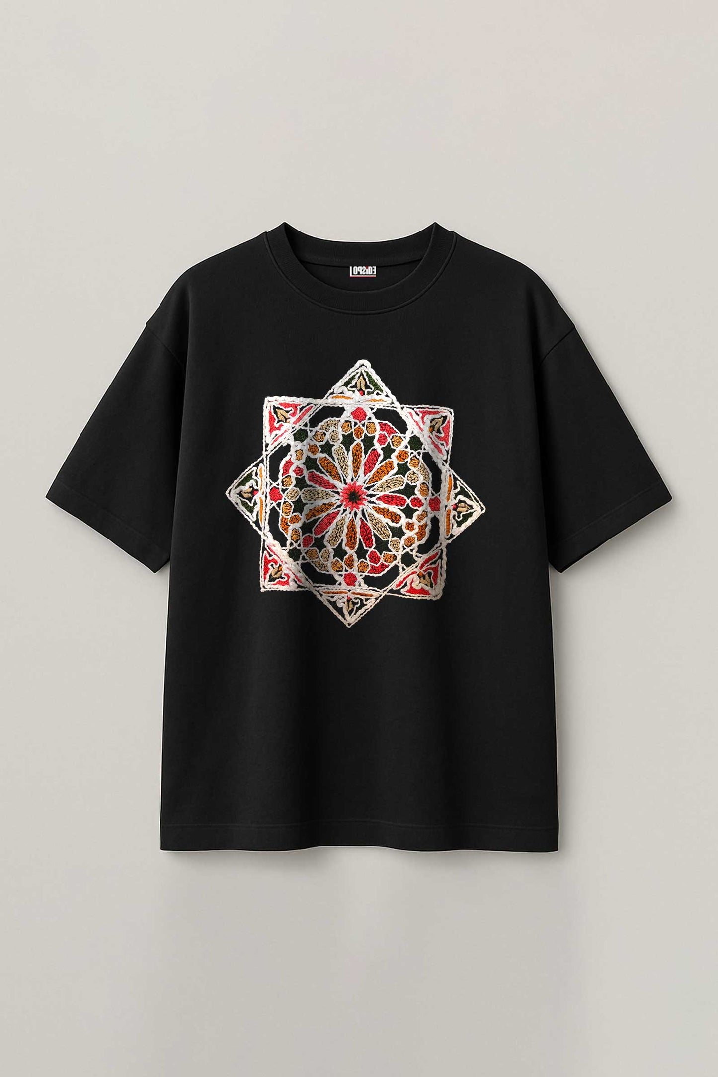 Black t-shirt with a colorful geometric design on a light gray background