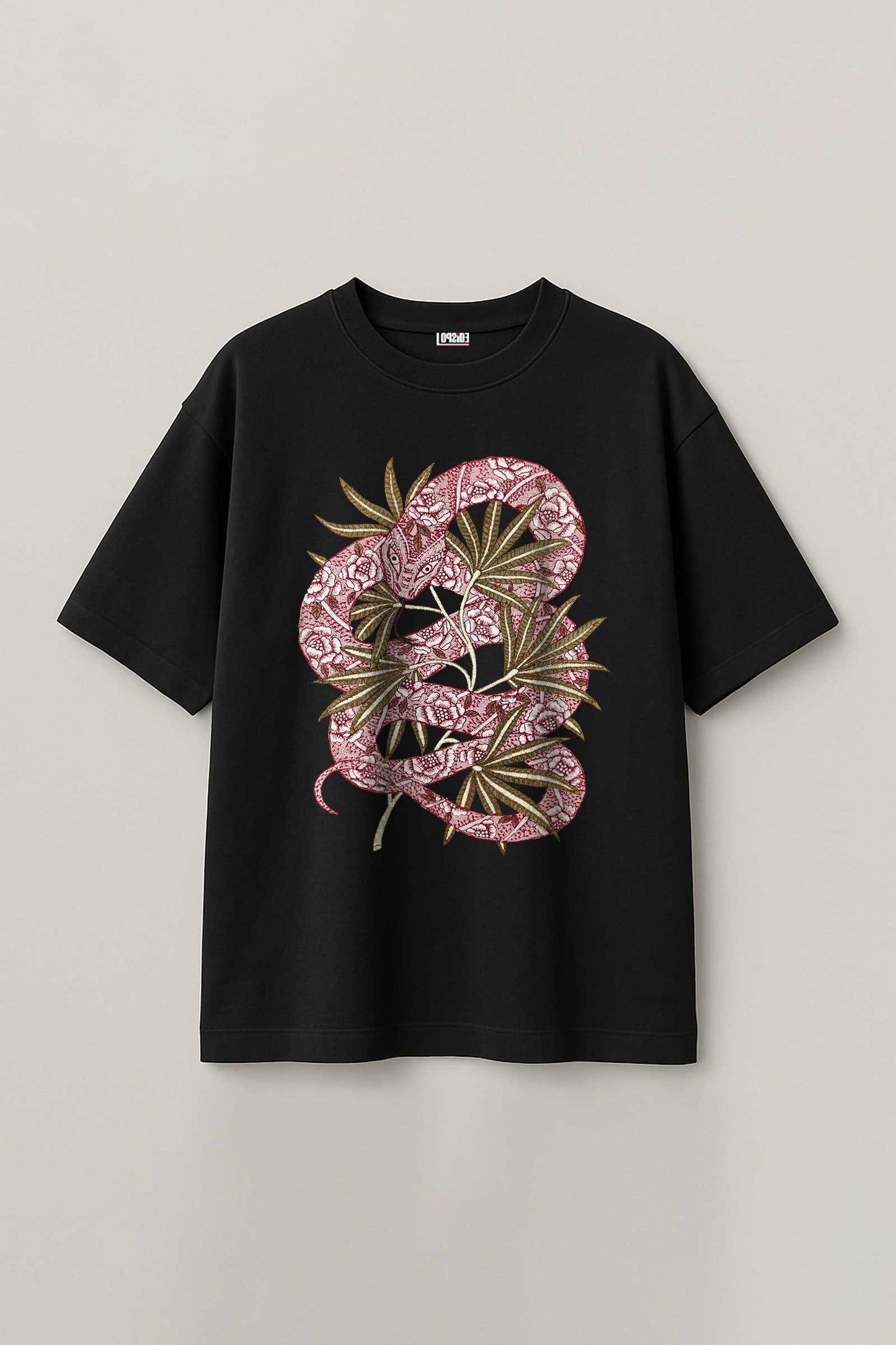 Black t-shirt with pink snake and leaf design on a light gray background