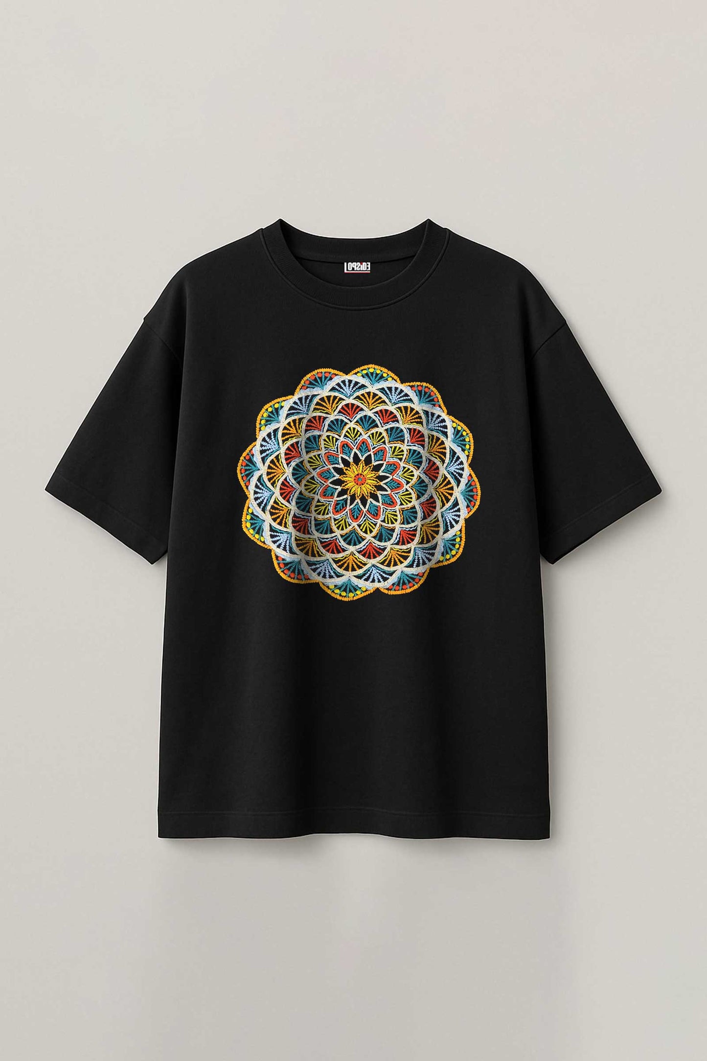 Black t-shirt with a colorful mandala embroidery design on a light gray background