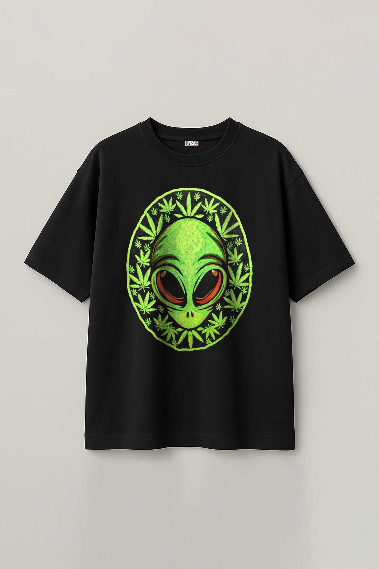 Black t-shirt with a green alien design on a gray background