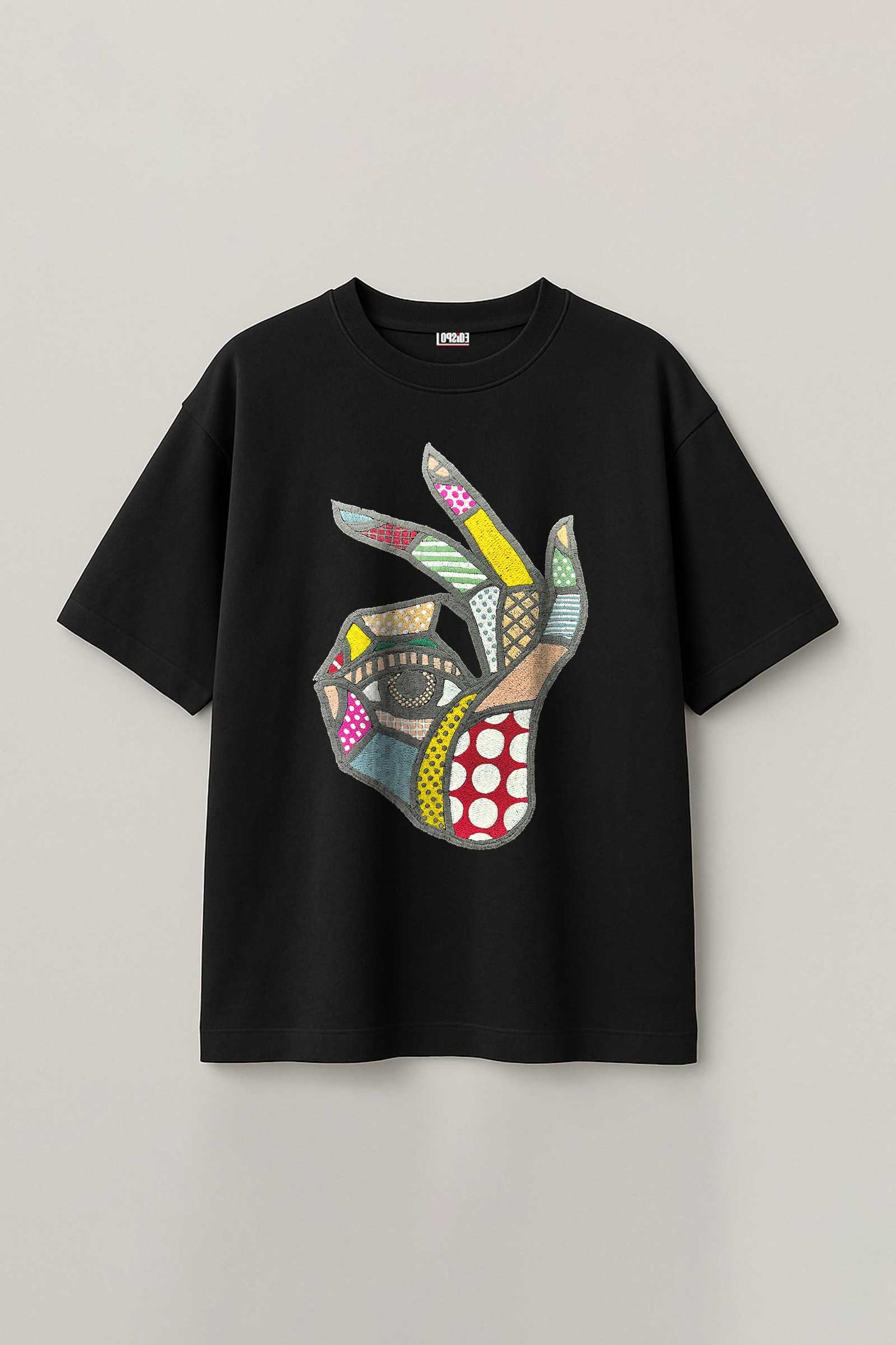 Black t-shirt with a colorful abstract design on a gray background