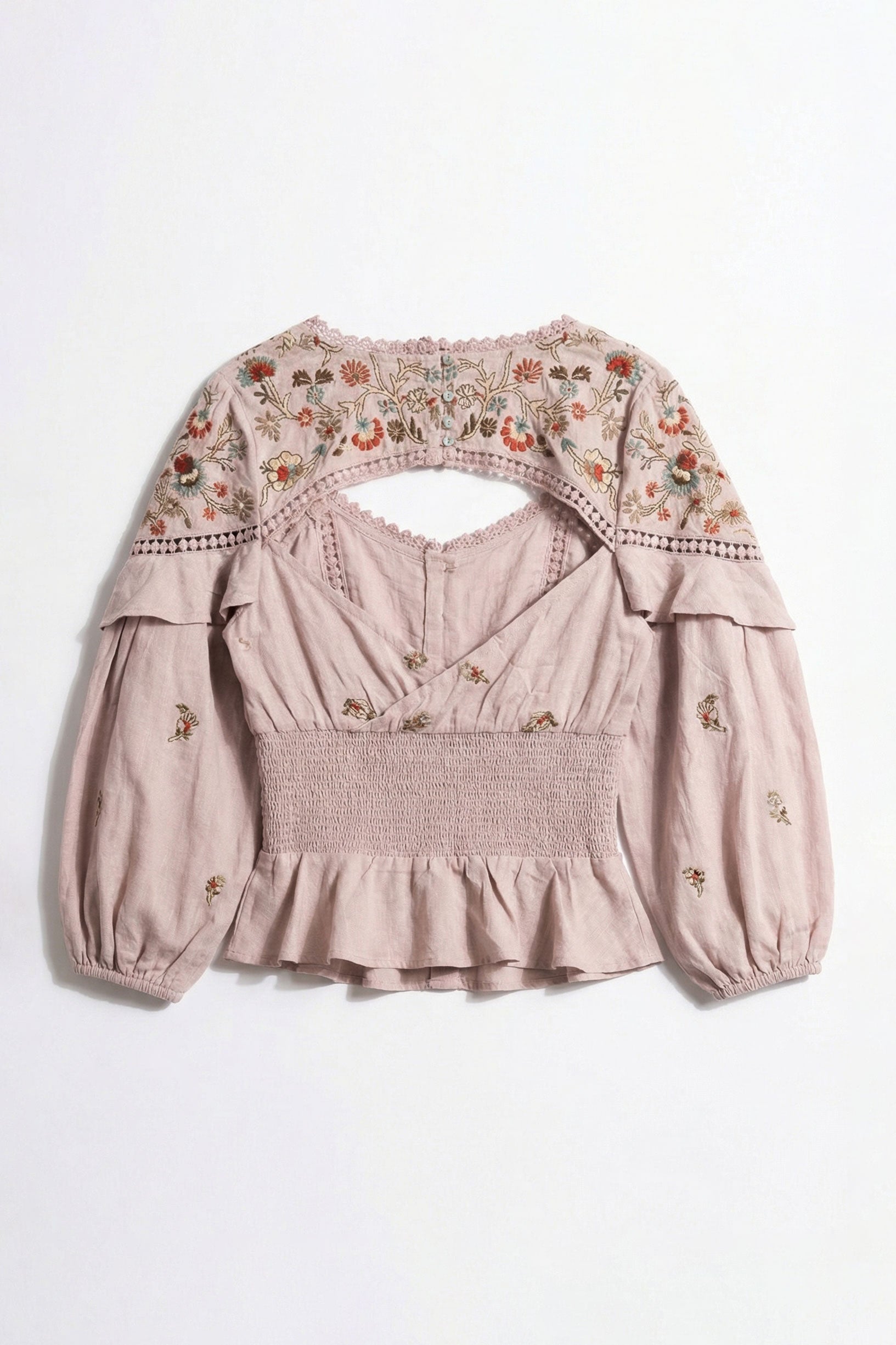 Pink blouse with floral embroidery on a white background