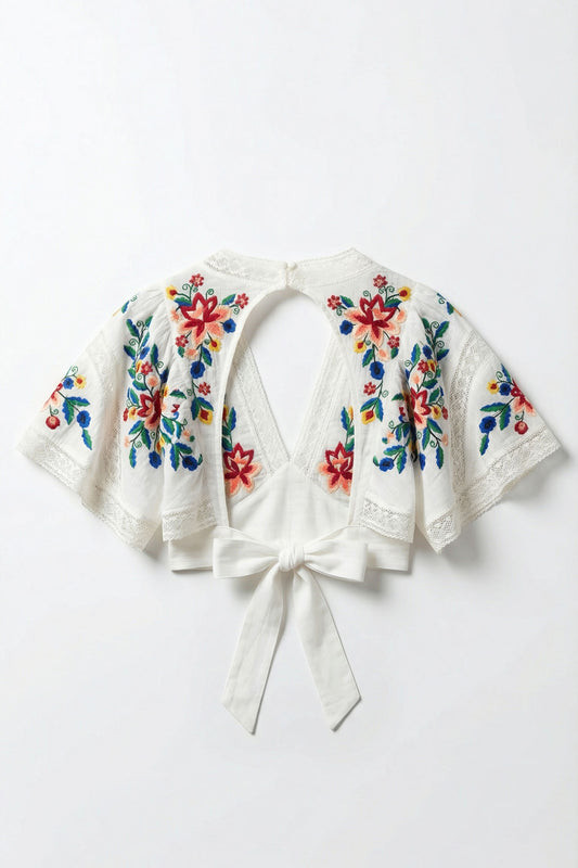 White embroidered jacket with colorful floral patterns on a white background