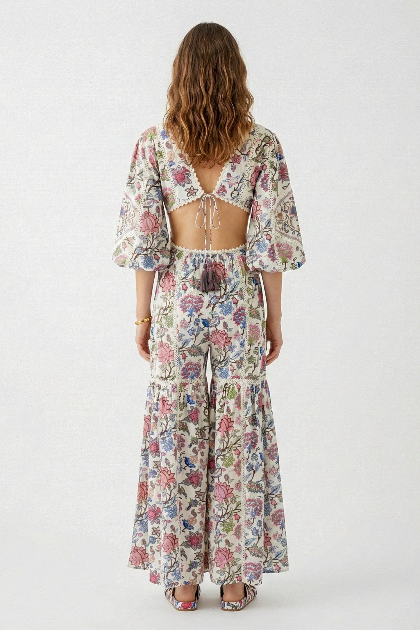 Woman wearing a floral jumpsuit on a white background