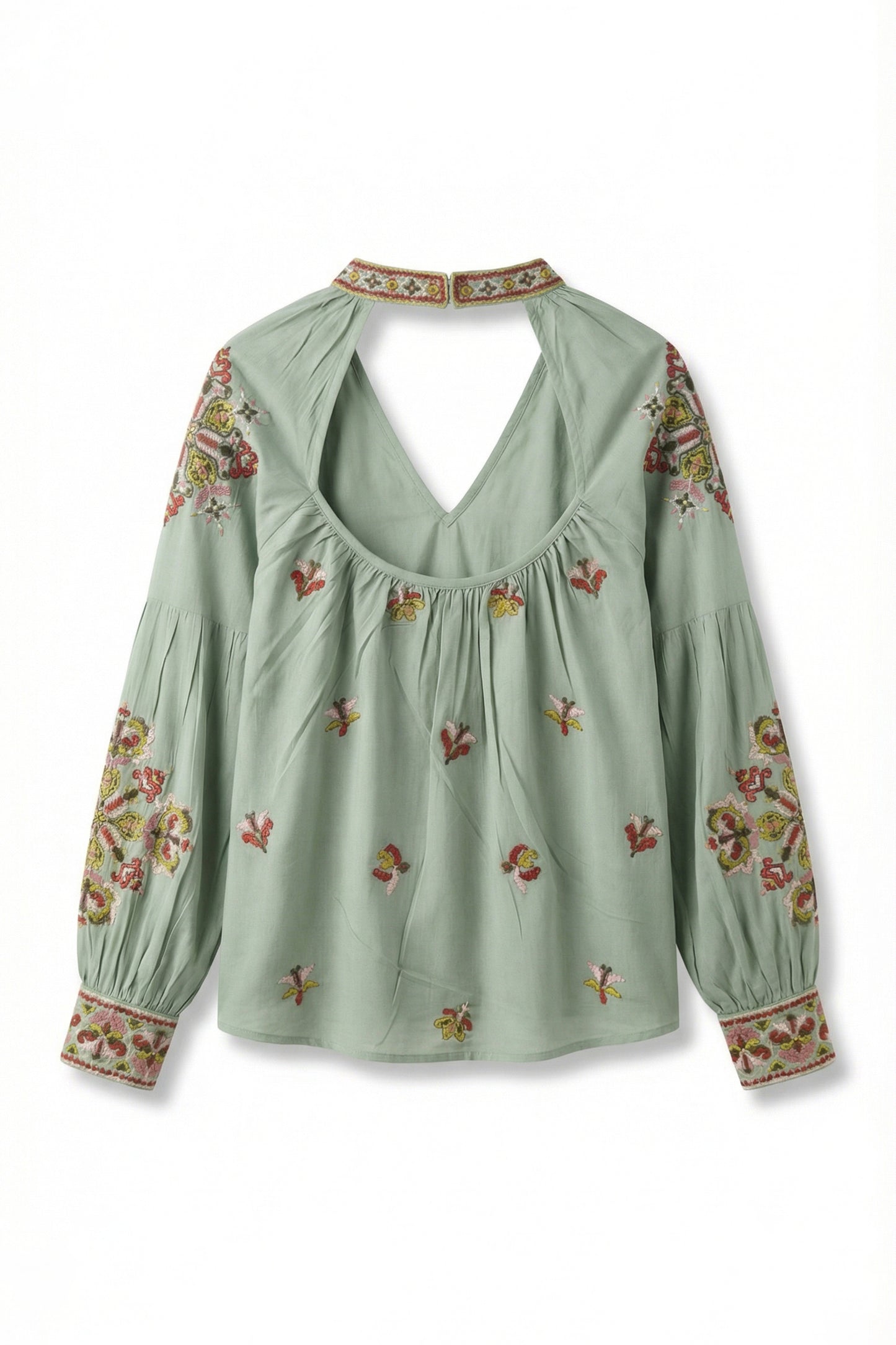 Green blouse with floral embroidery on a white background