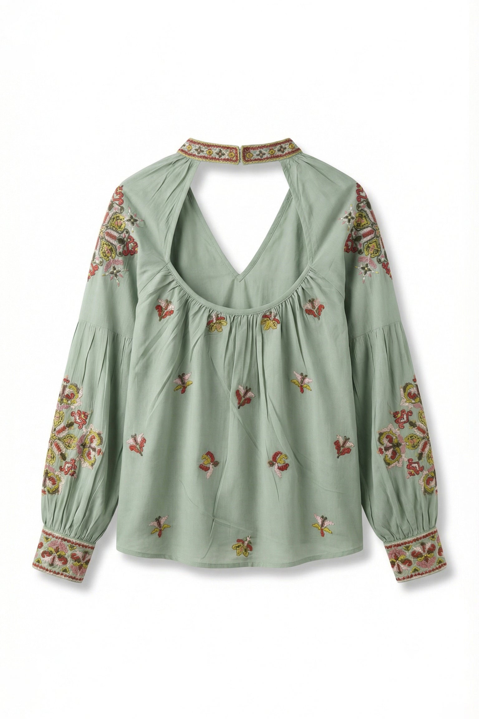 Green blouse with floral embroidery on a white background