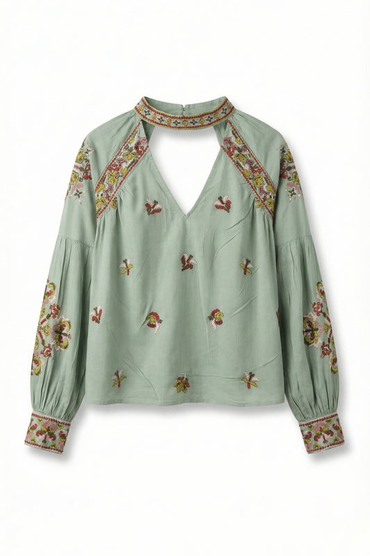 Green blouse with floral embroidery on a white background