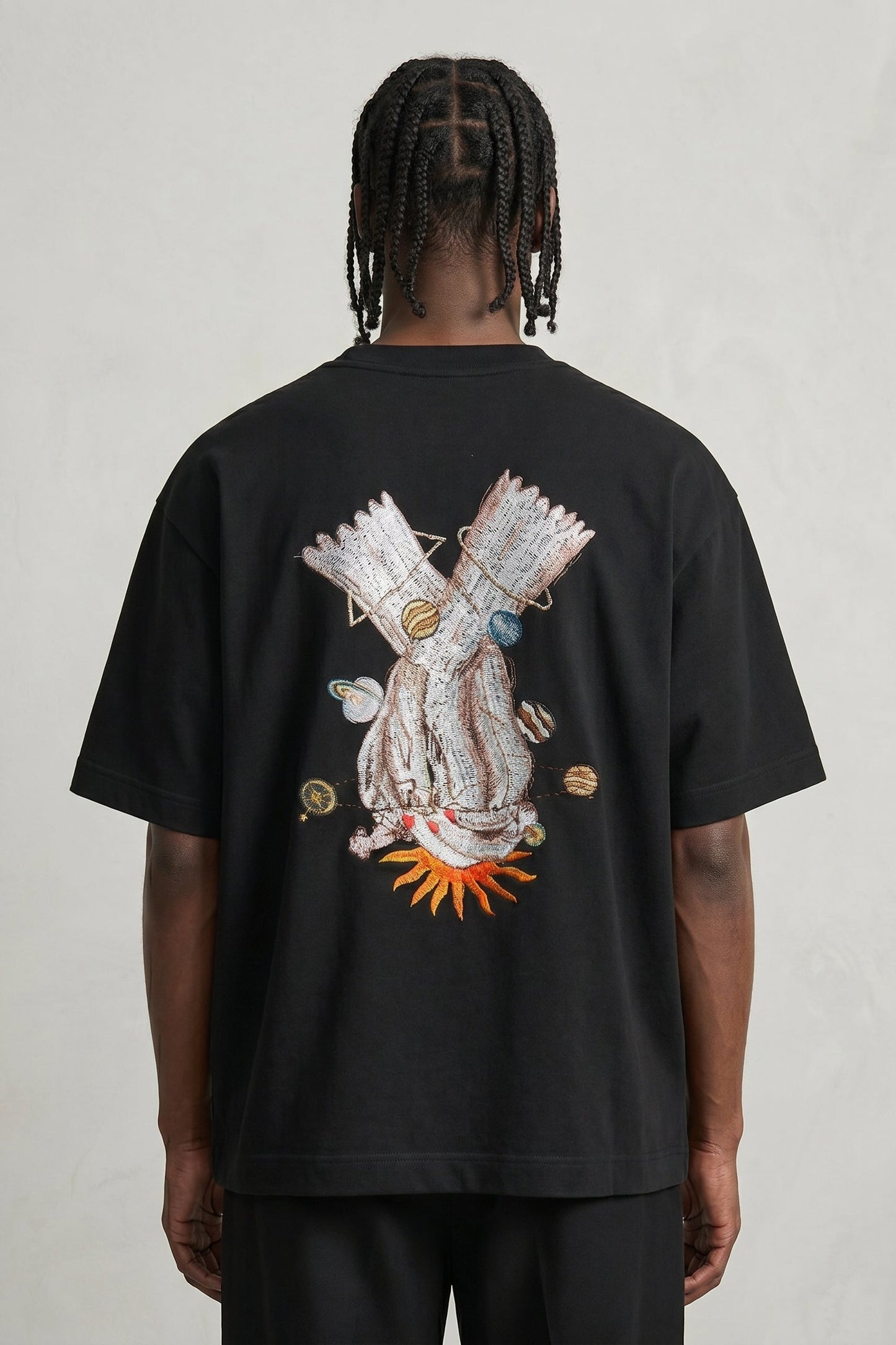Person wearing a black t-shirt with a colorful graphic on the back against a plain background
