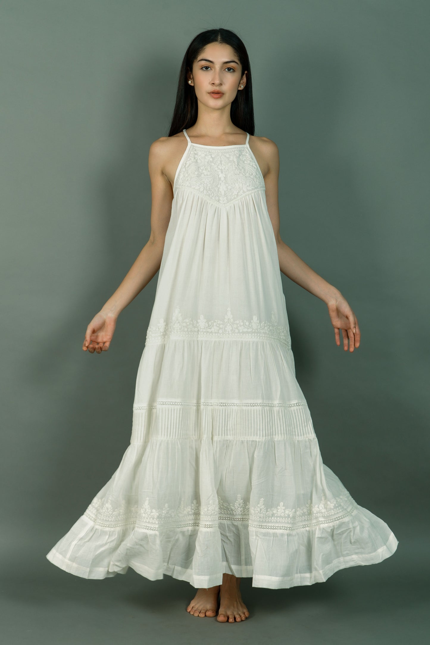 Woman wearing a white lace dress against a gray background
