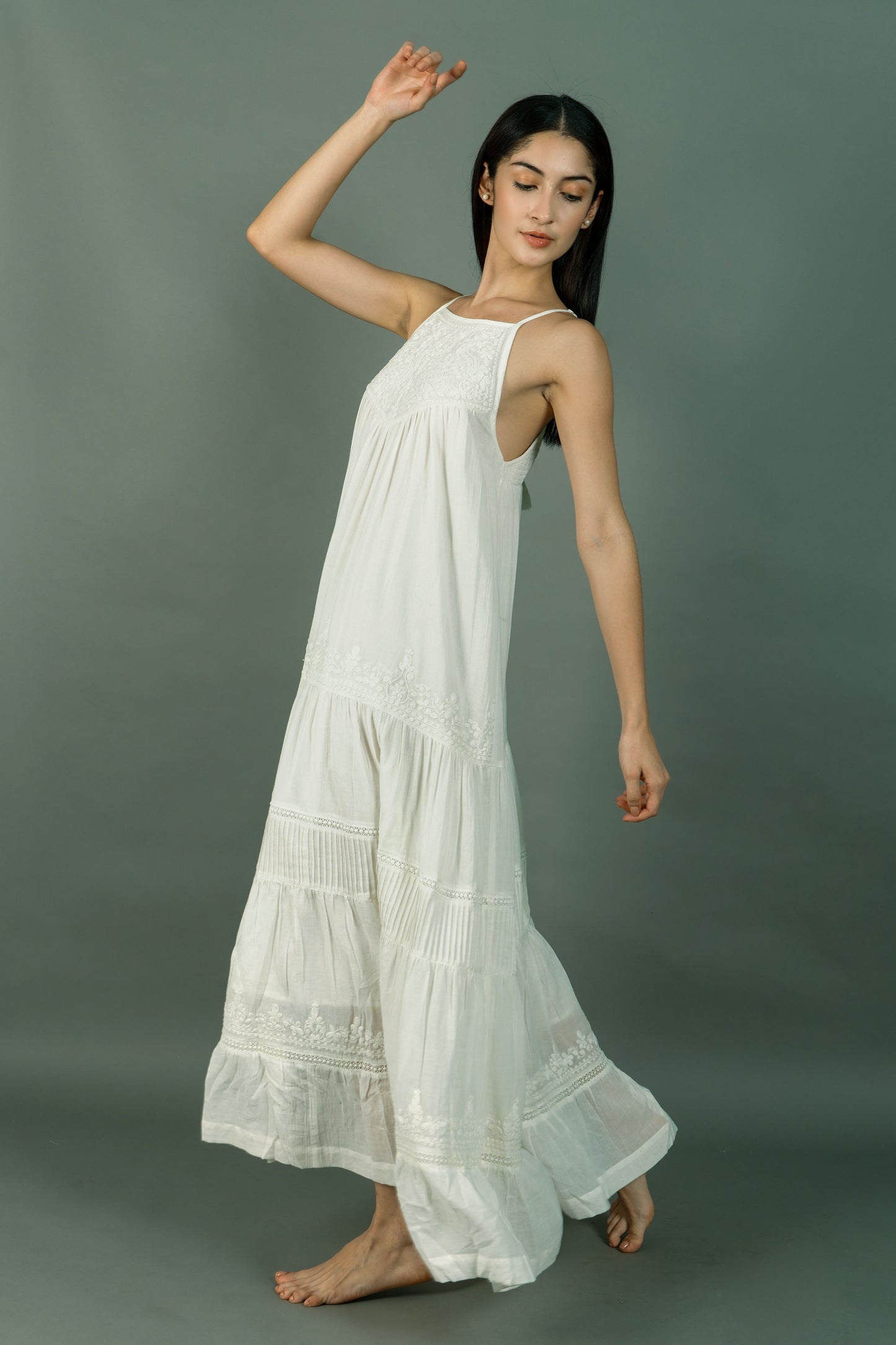 Woman wearing a white dress against a gray background
