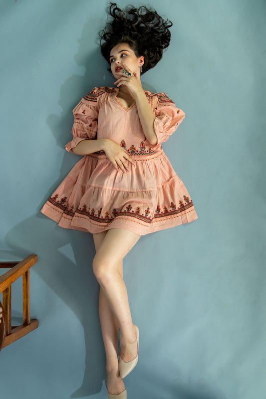 Woman in a vintage-style dress against a light blue wall
