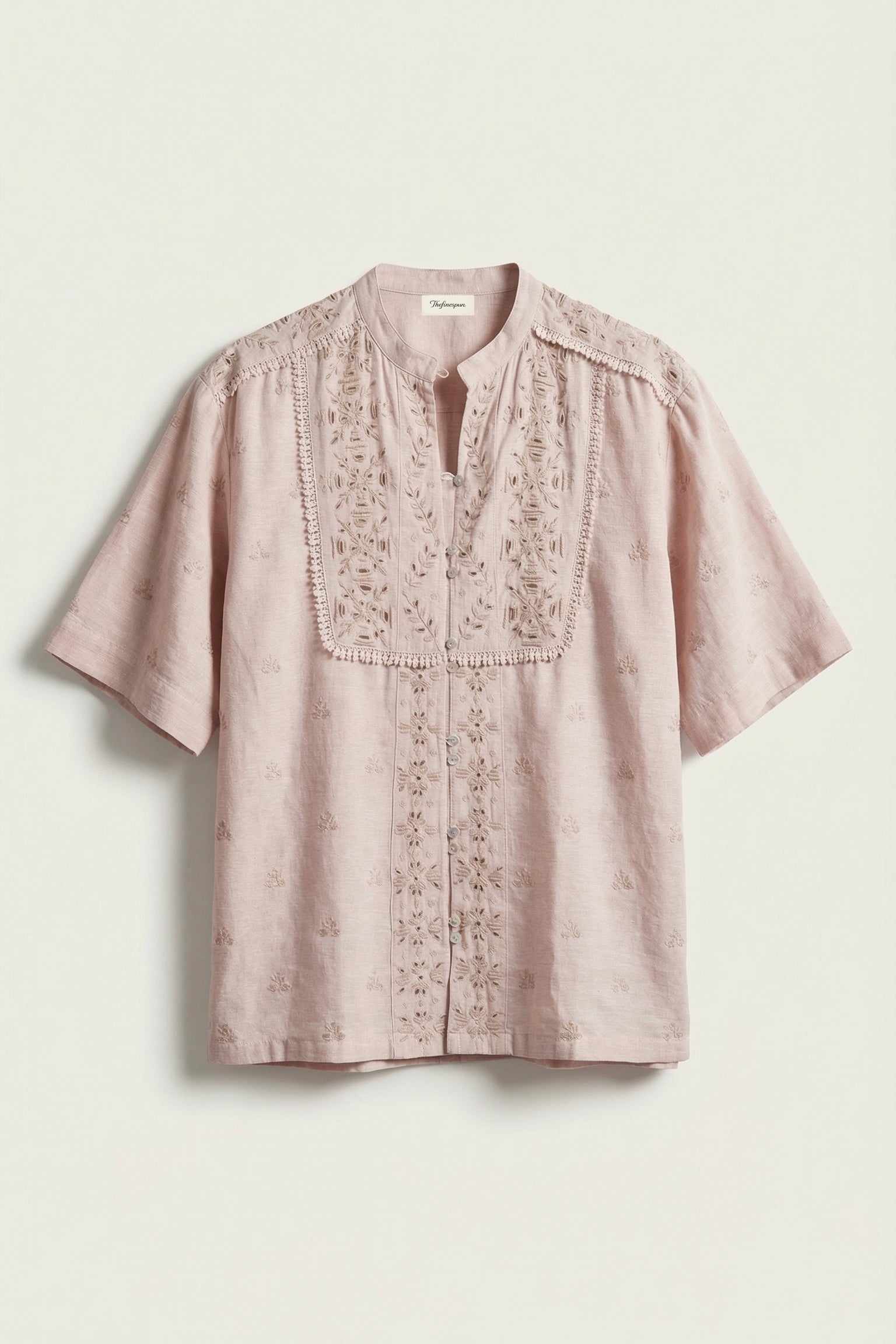 Pink embroidered blouse on a light beige background
