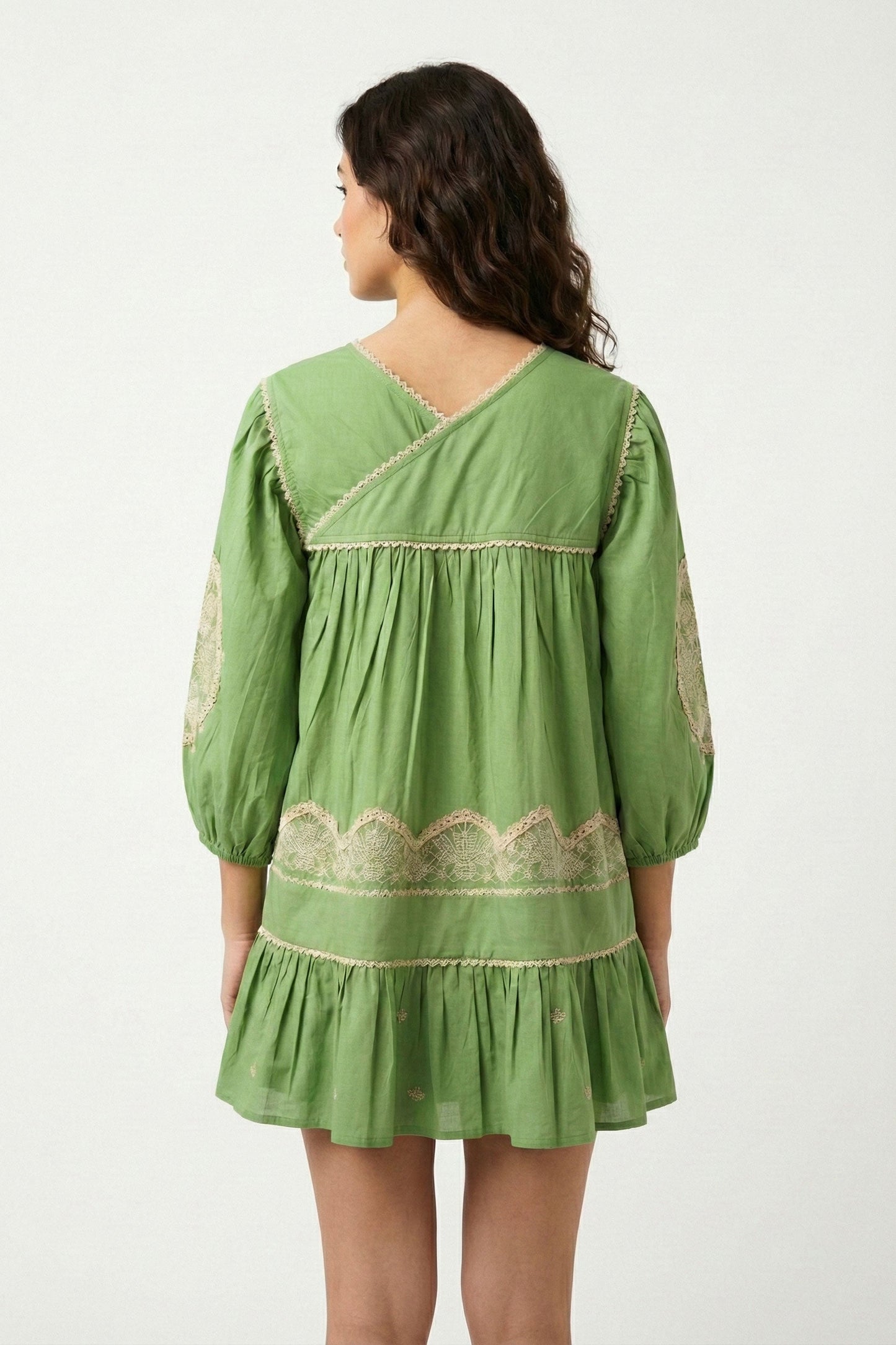 Green dress with lace details on a white background