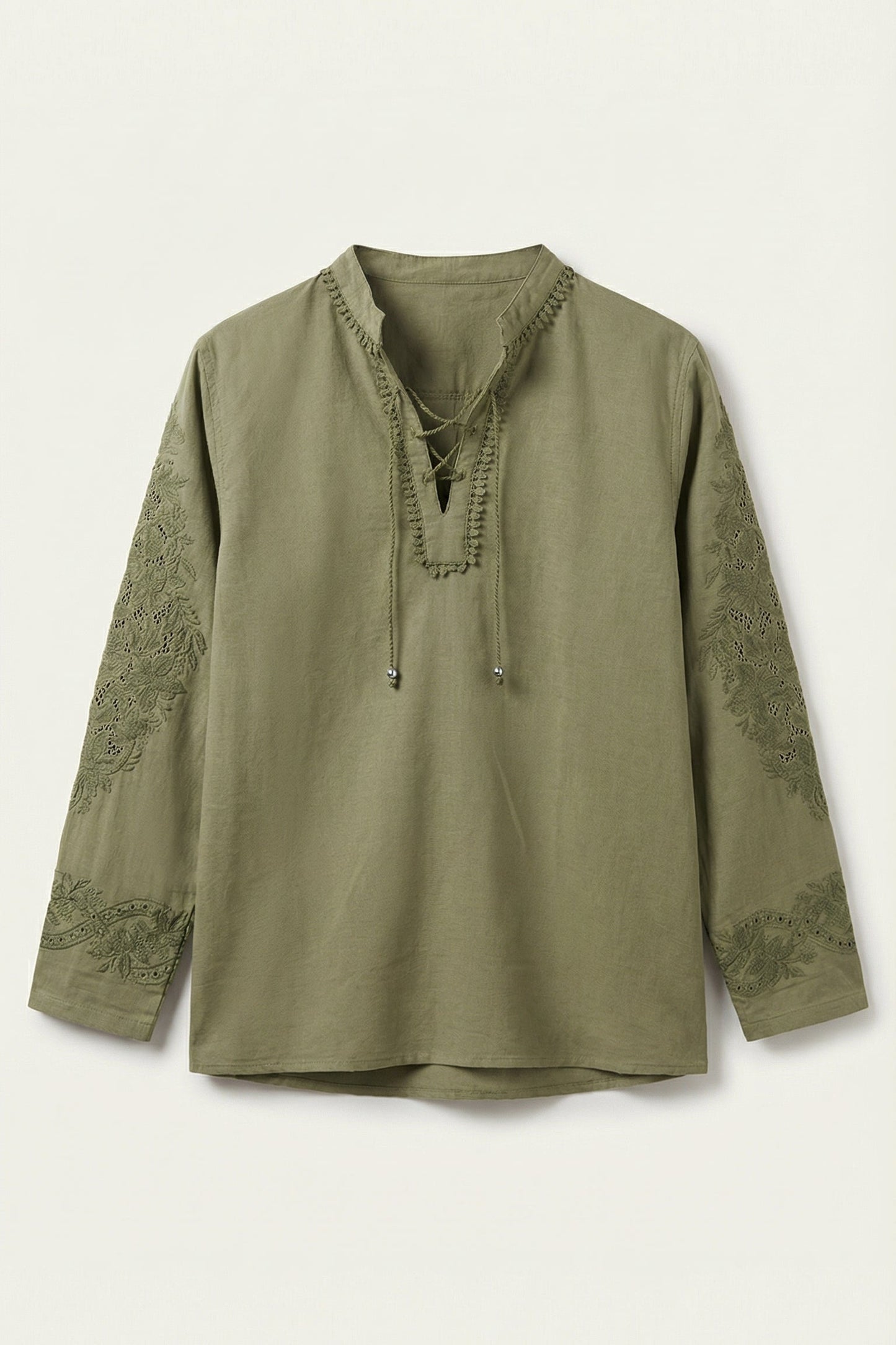 Green long-sleeve top with lace details on a white background