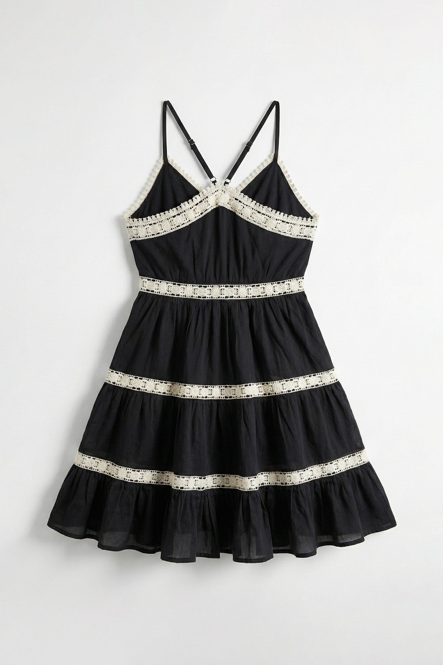 Black dress with white lace details on a white background