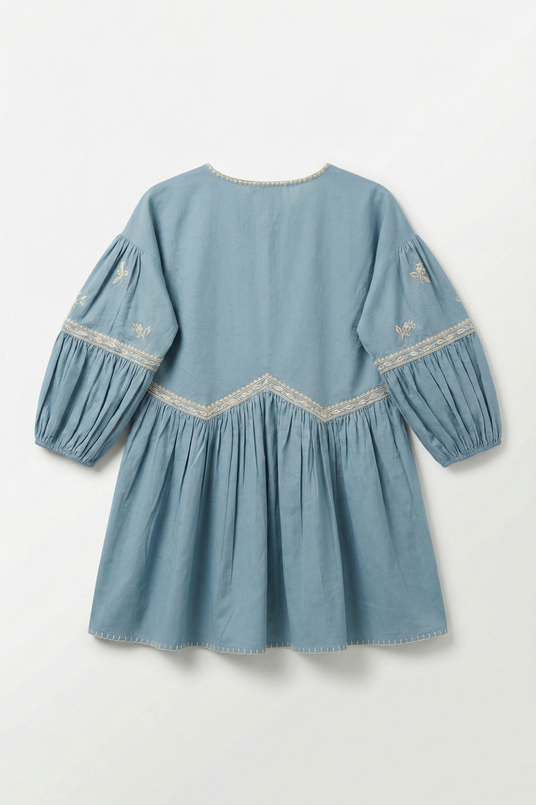 Blue dress with embroidered details on a light gray background