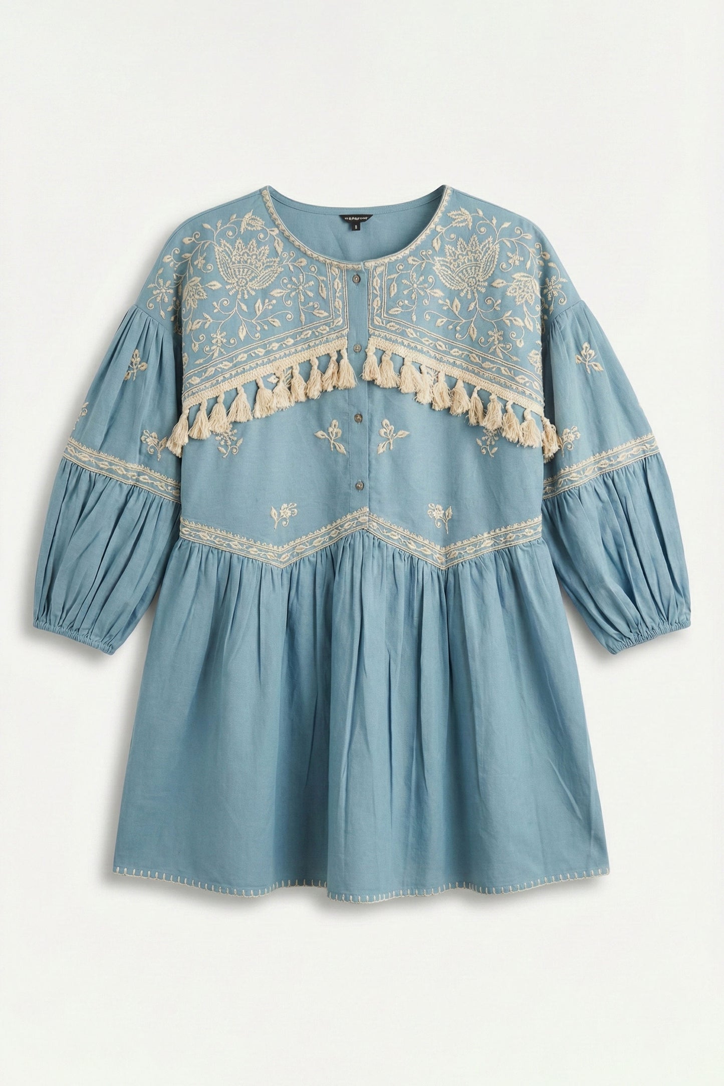 Blue dress with embroidery and tassel details on a white background