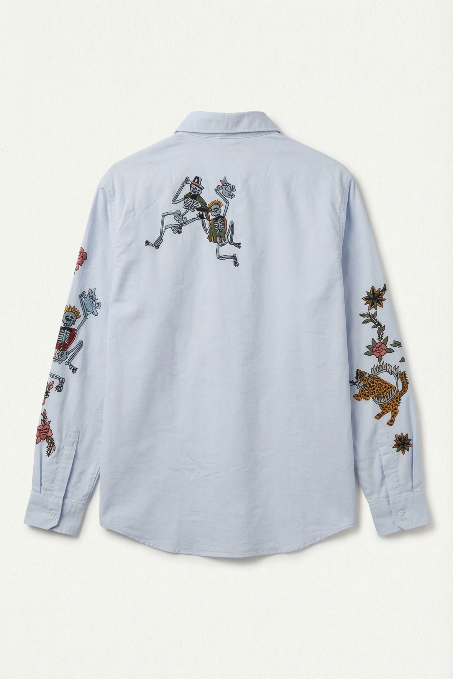 Light blue shirt with colorful embroidered designs on a white background