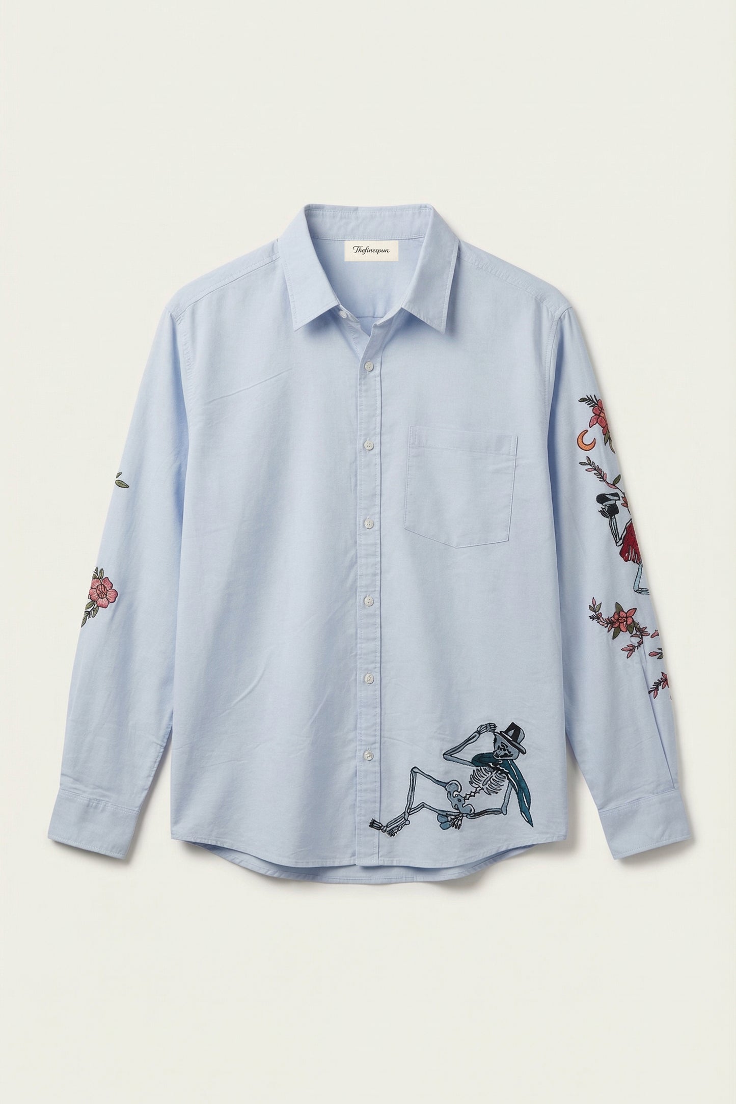 Light blue shirt with embroidered designs on a white background