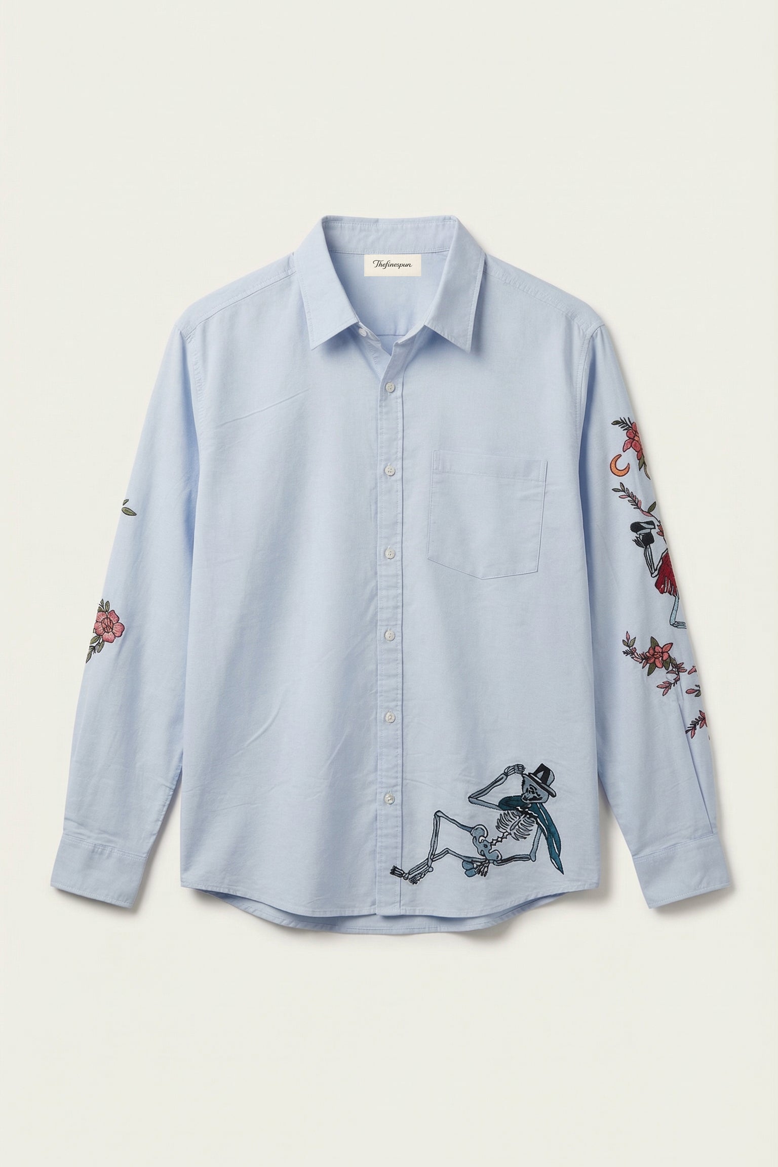 Light blue shirt with embroidered designs on a white background