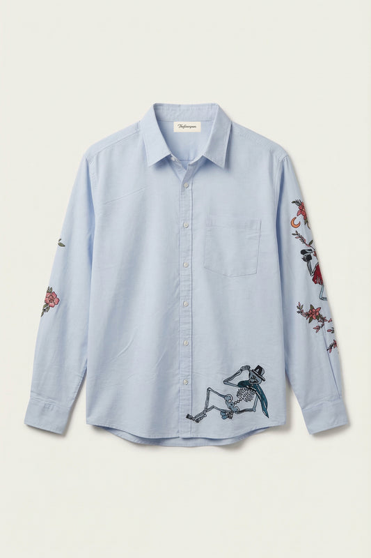 Light blue shirt with embroidered designs on a white background