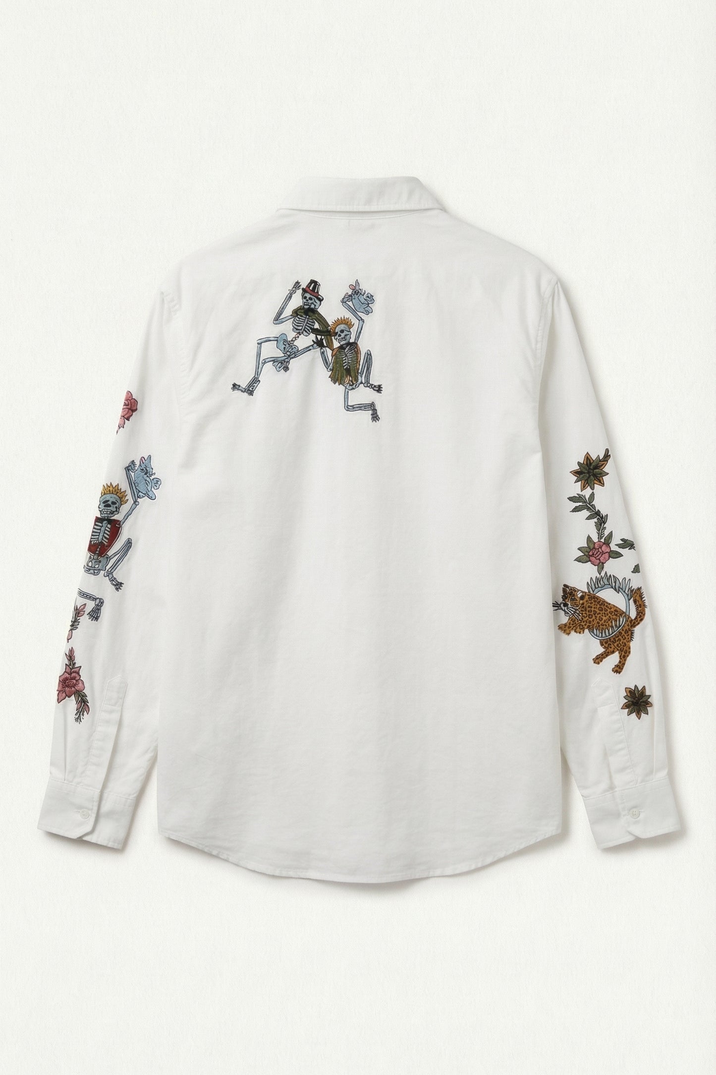 White shirt with colorful embroidered designs on a white background