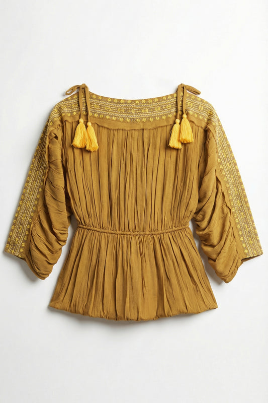 Mustard yellow blouse with tassels on a white background