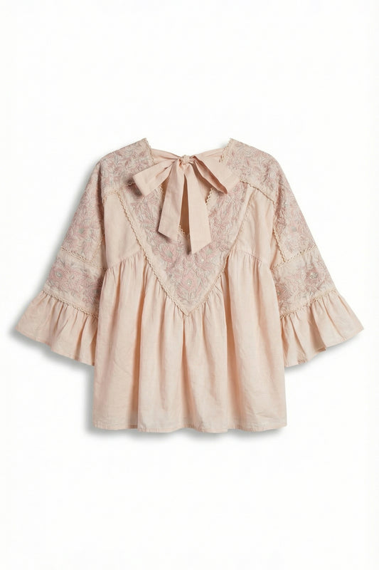 Beige blouse with lace details and a bow on a white background