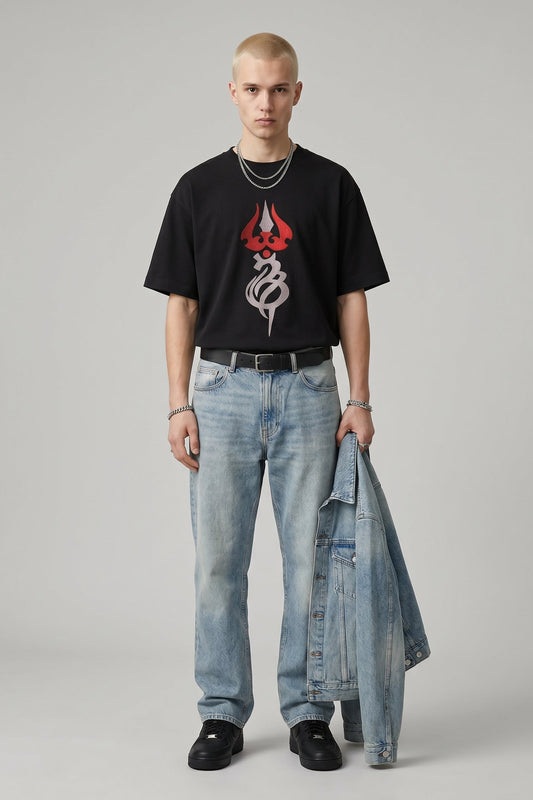 Person wearing a black t-shirt with a red and white logo and light blue jeans on a gray background