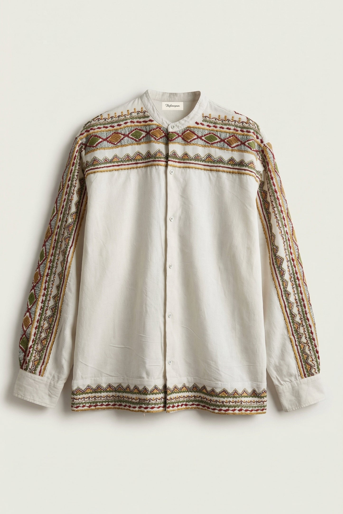 White Shirt with intricate brown and beige embroidery on a light background