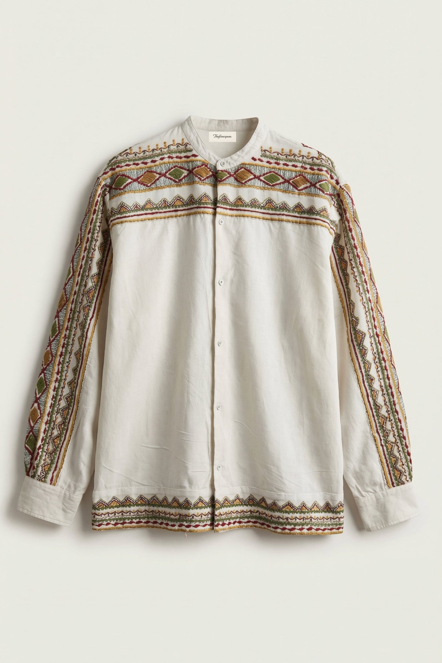 White Shirt with intricate brown and beige embroidery on a light background