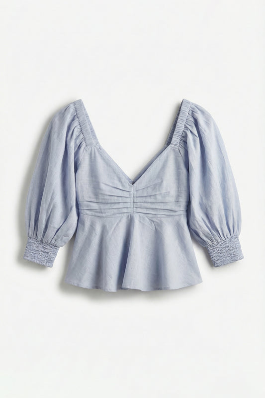 Light blue blouse with puff sleeves on a white background