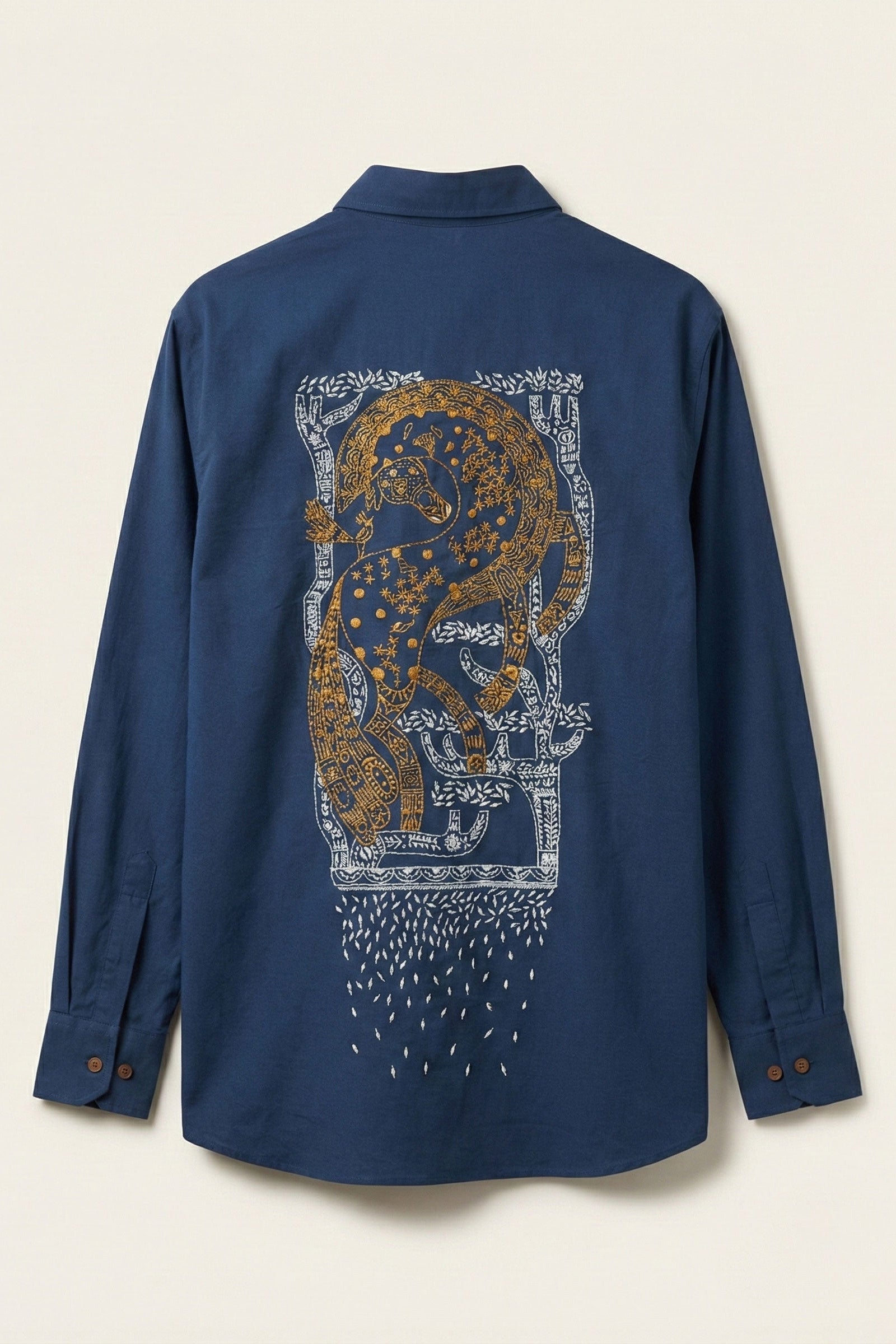 Blue shirt with a decorative lion design on the back against a beige background