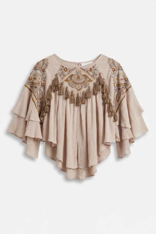 Beige blouse with intricate patterns and tassels on a white background