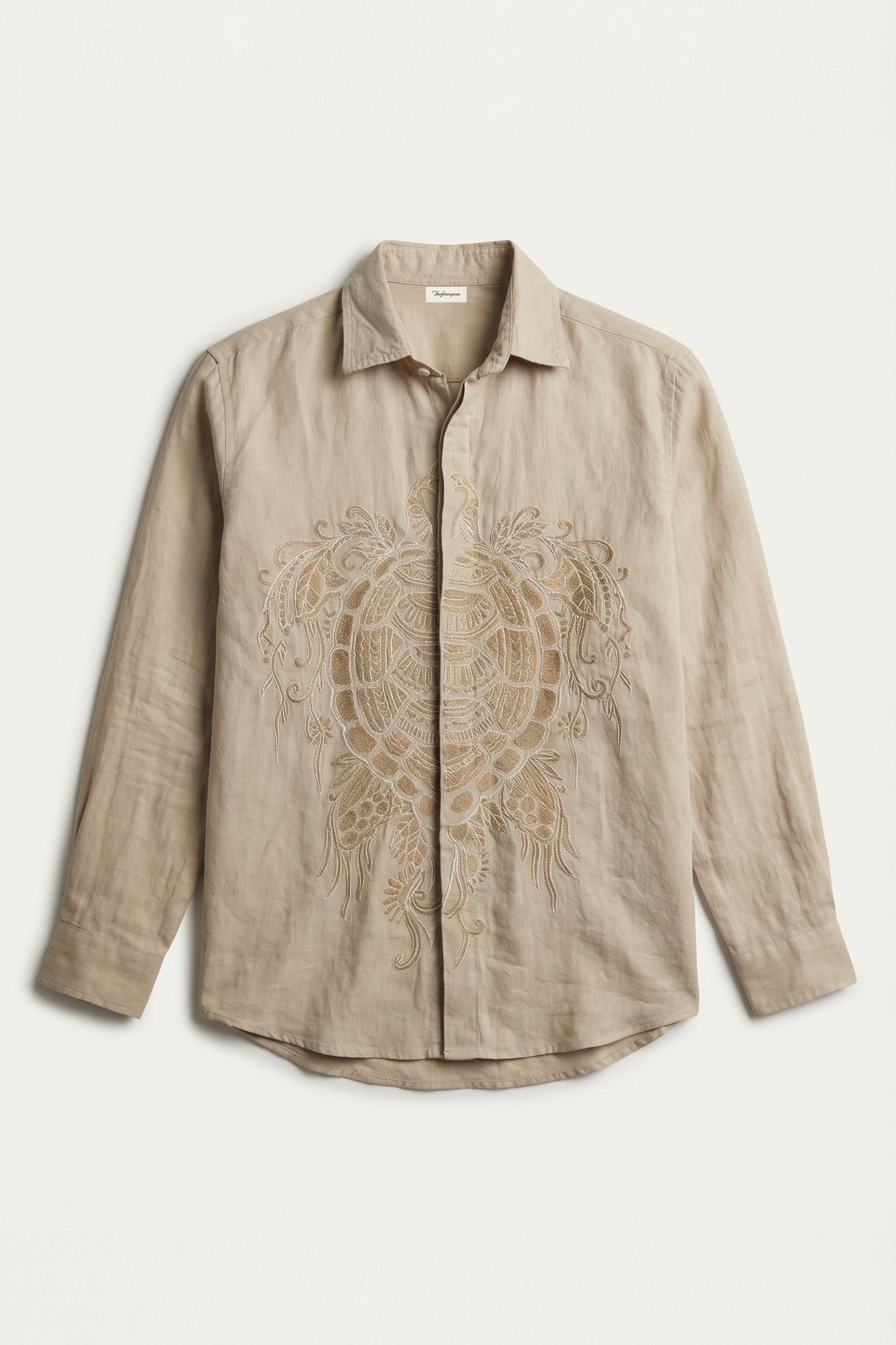 Beige shirt with intricate embroidery on a light beige background
