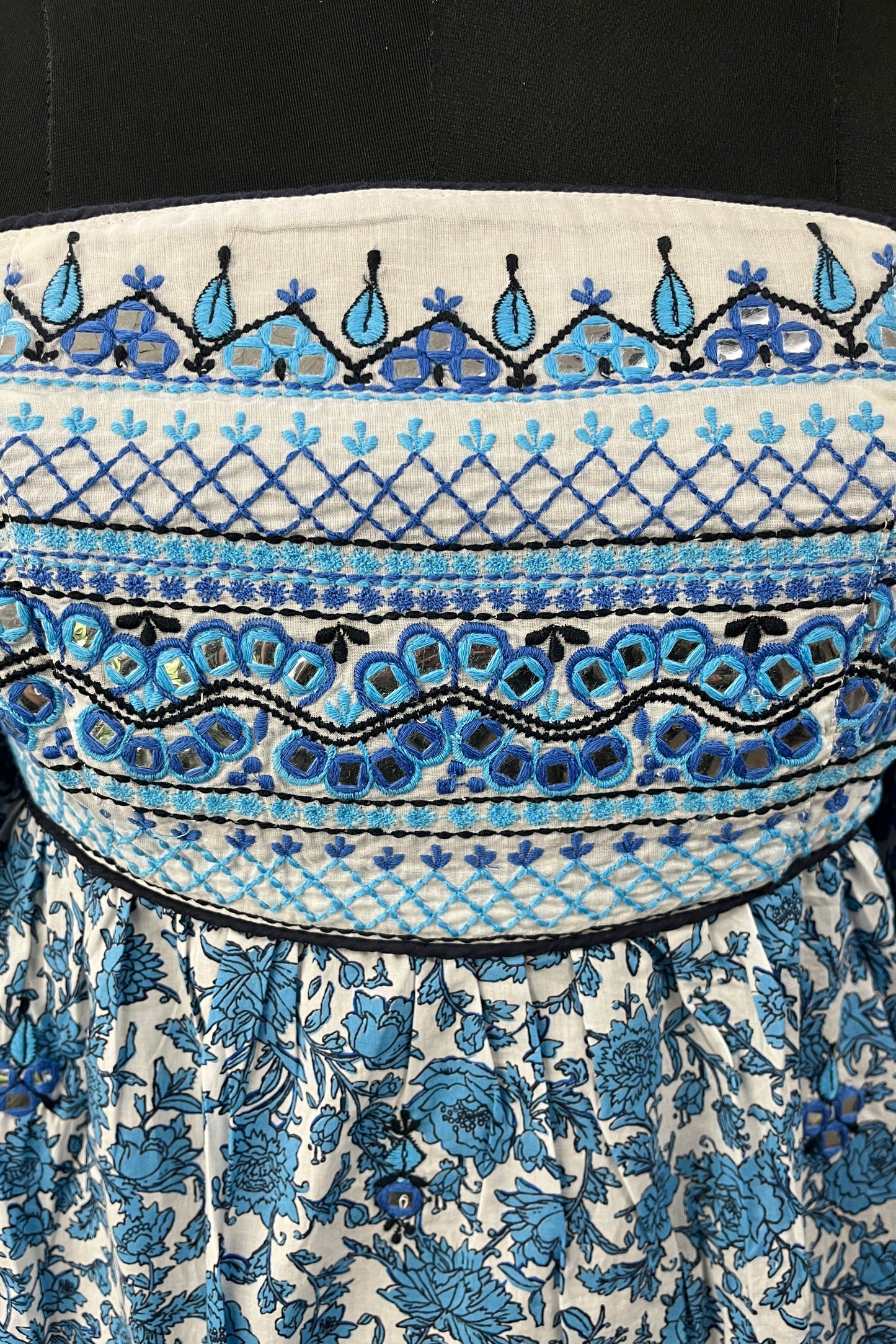 Close-up of a patterned fabric with blue and black designs on a white background