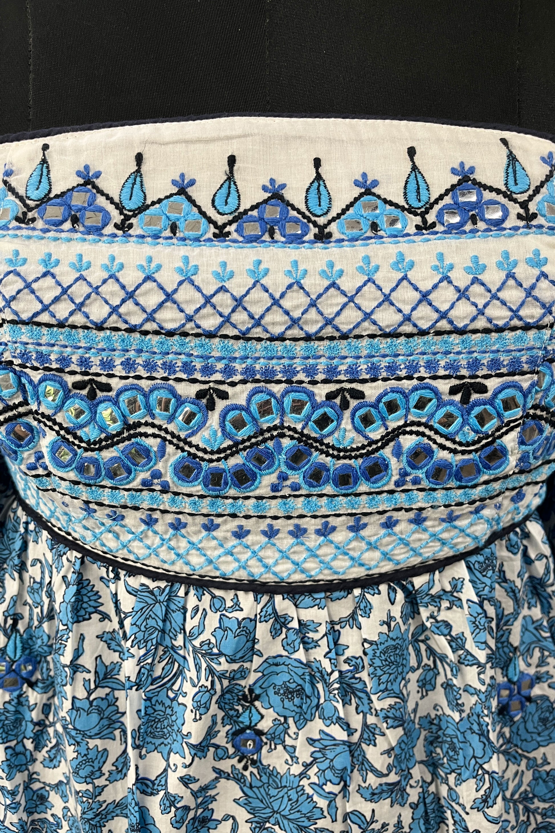 Close-up of a patterned fabric with blue and black designs on a white background