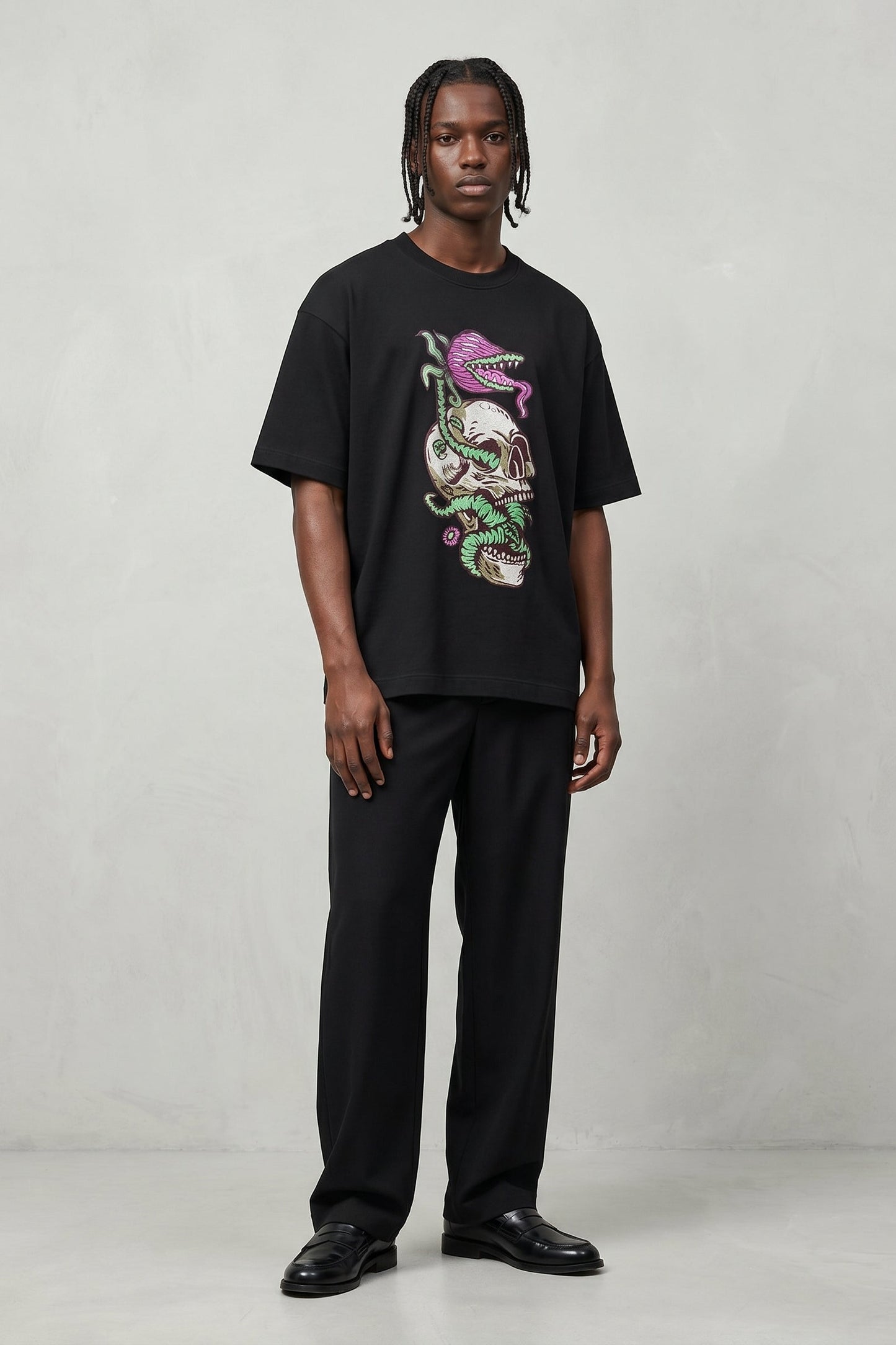 Person wearing a black t-shirt with a colorful graphic design on a plain background