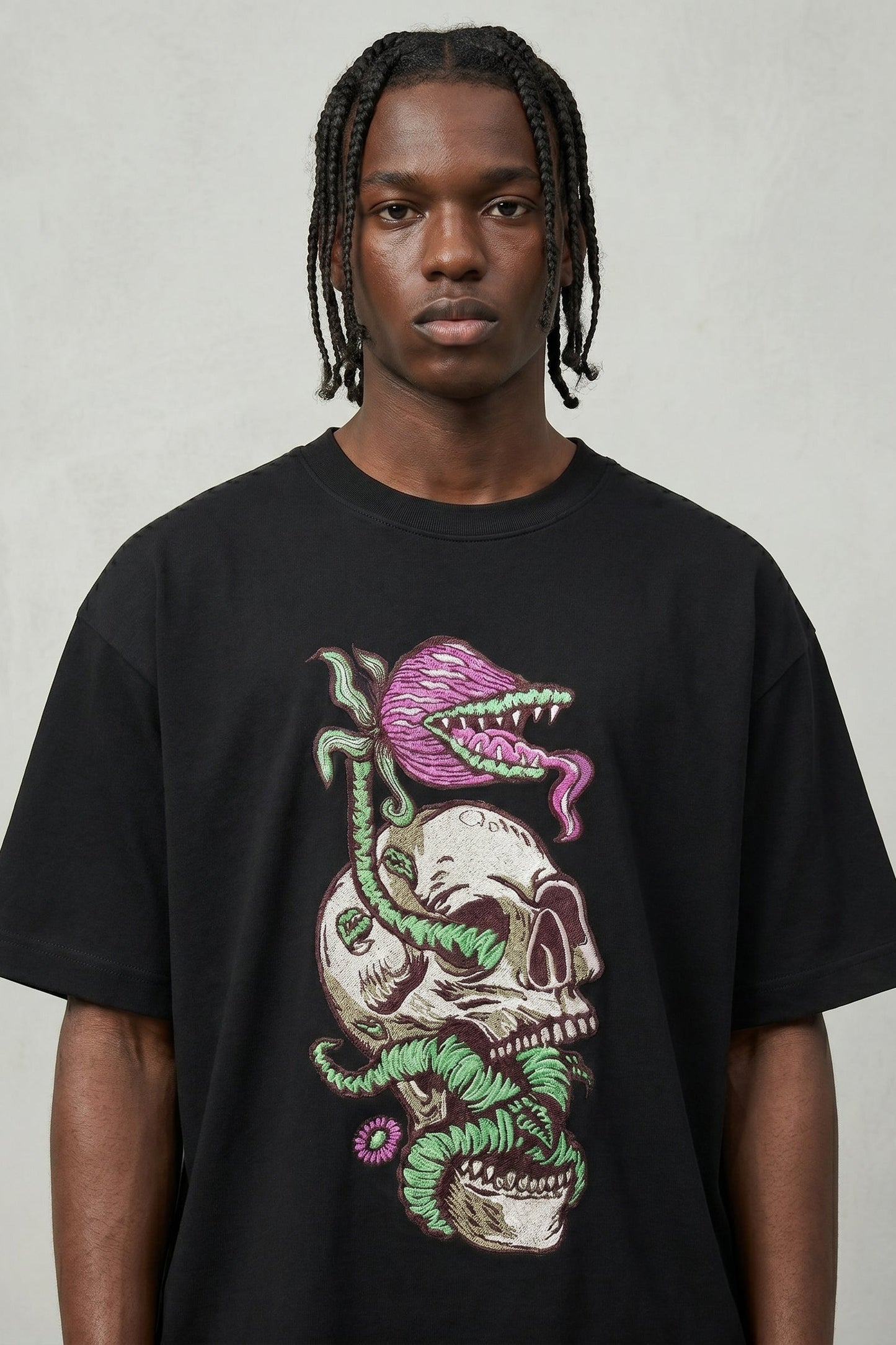 Person wearing a black t-shirt with a colorful graphic design on a plain background