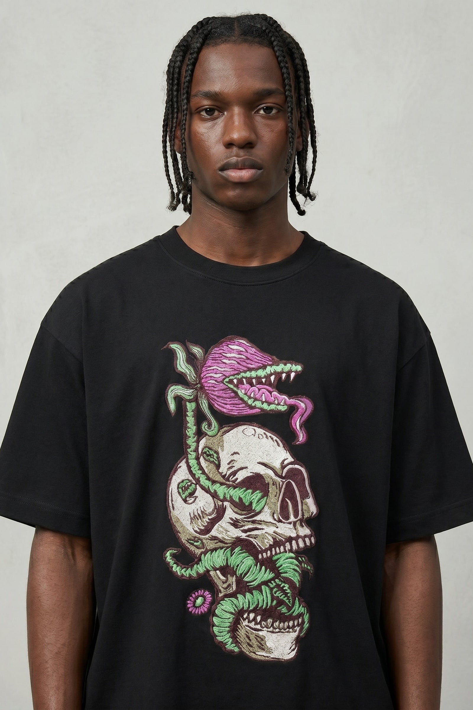 Person wearing a black t-shirt with a colorful graphic design on a plain background