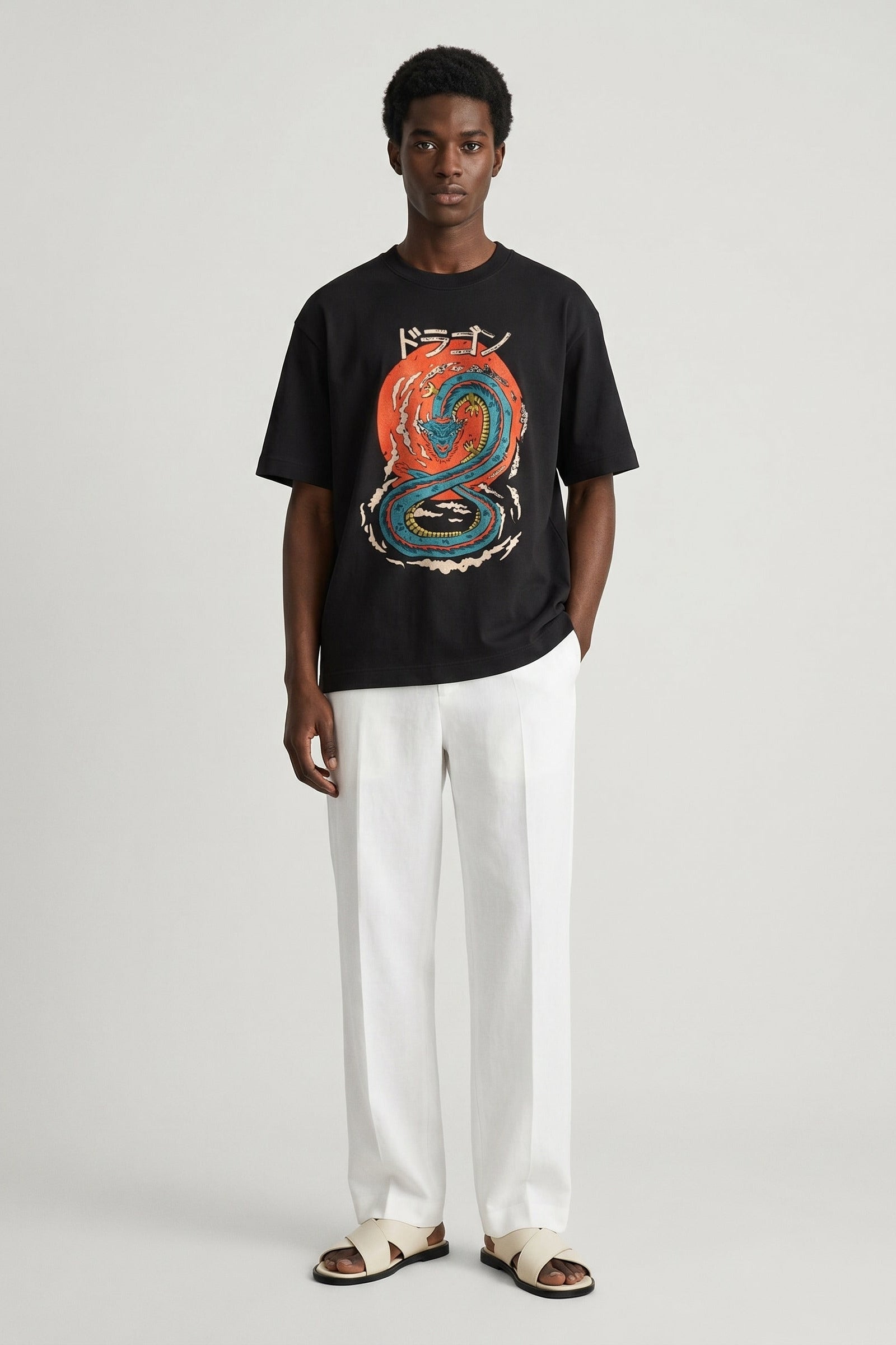 Person wearing a black t-shirt with a colorful graphic design on a plain background