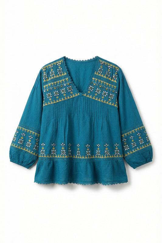 Teal blouse with gold embroidery on a white background