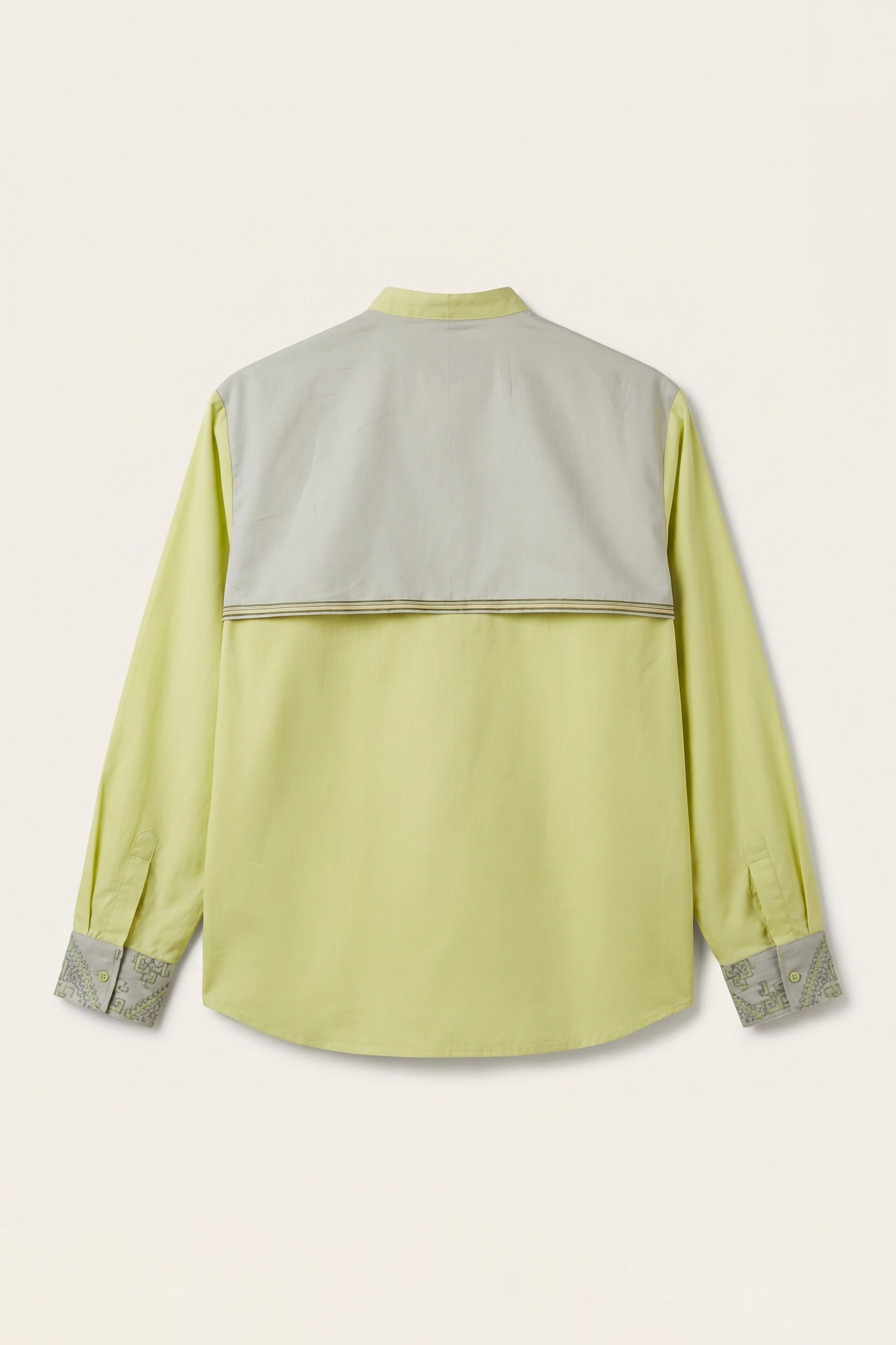 Light green shirt with gray accents on a beige background